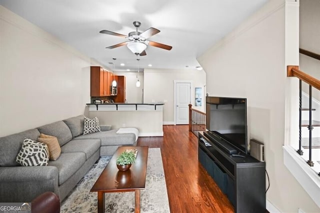 living room featuring dark hardwood / wood-style floors, ceiling fan, and ornamental molding