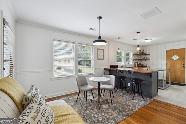 dining room featuring crown molding, sink, and wood-type flooring