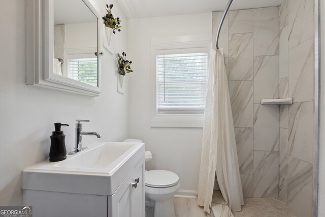 bathroom with curtained shower, vanity, a healthy amount of sunlight, and toilet