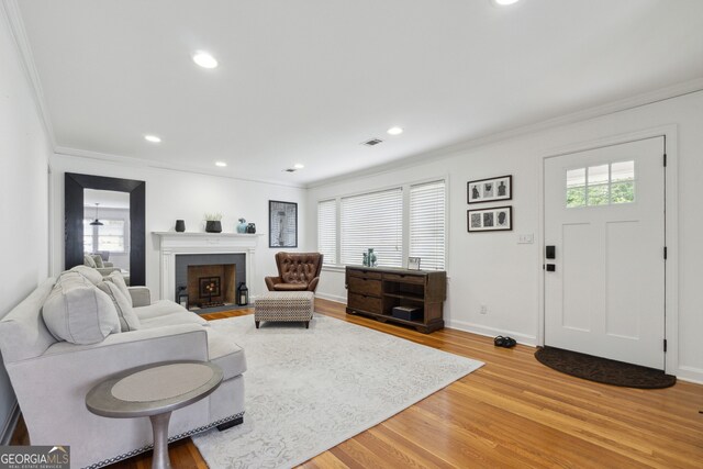 living room with hardwood / wood-style floors, a healthy amount of sunlight, and ornamental molding