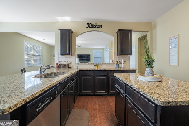 kitchen featuring light stone countertops, dishwasher, sink, tasteful backsplash, and dark hardwood / wood-style floors