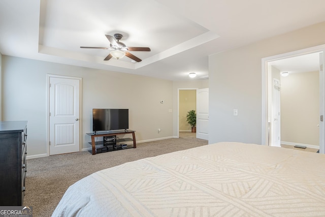 bedroom featuring light carpet, a raised ceiling, and ceiling fan