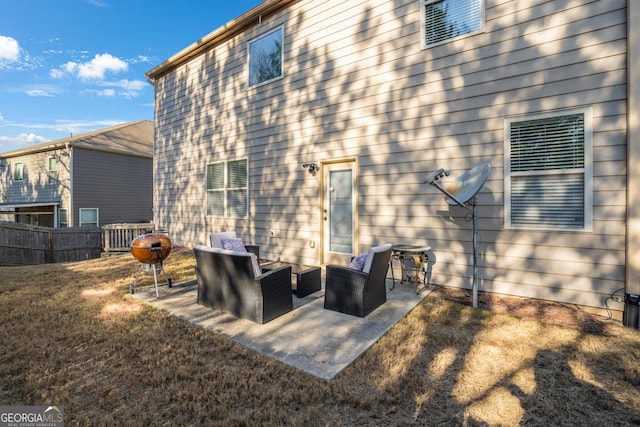 back of house with an outdoor living space, a patio, and a lawn