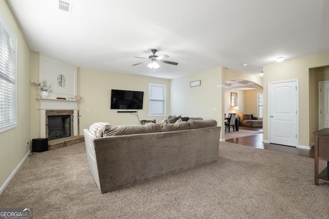 carpeted living room with ceiling fan