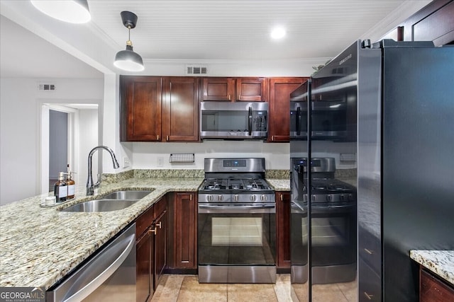 kitchen featuring pendant lighting, sink, light tile patterned floors, light stone countertops, and appliances with stainless steel finishes