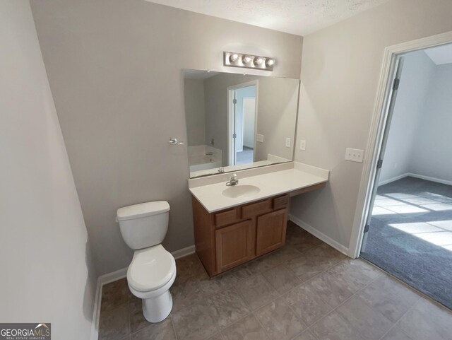 bathroom with vanity, a textured ceiling, and toilet