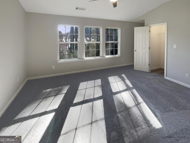 carpeted spare room featuring ceiling fan and vaulted ceiling