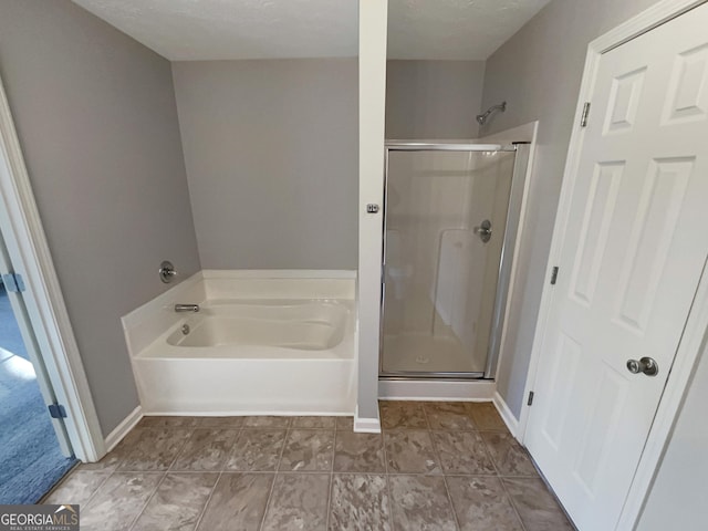 bathroom featuring plus walk in shower and a textured ceiling