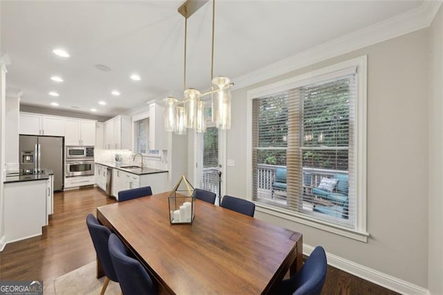 dining space featuring dark hardwood / wood-style flooring, sink, and ornamental molding