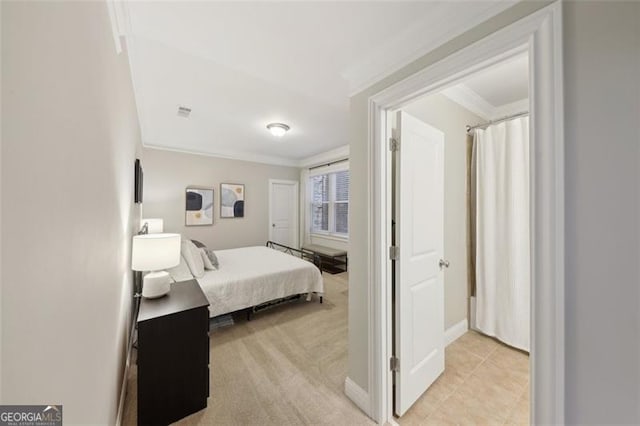 bedroom with crown molding and light colored carpet