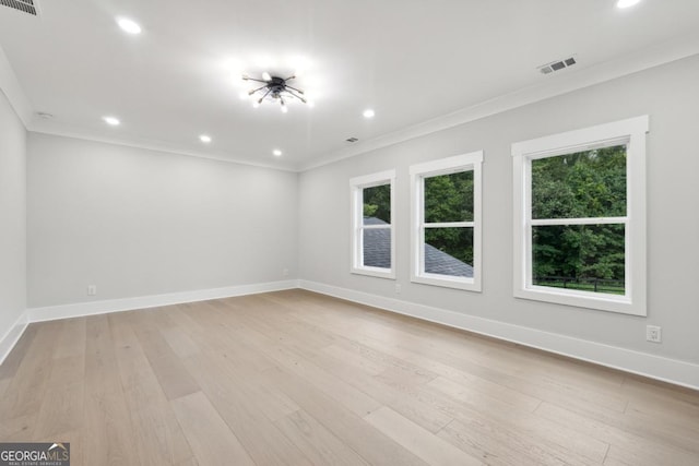 unfurnished room with light wood-type flooring and ornamental molding