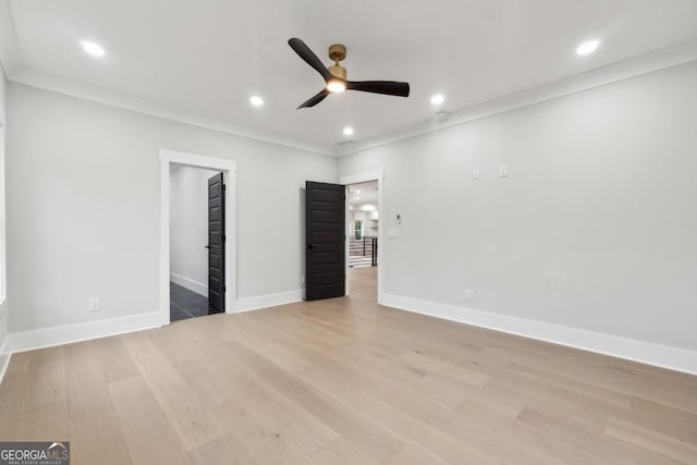 unfurnished bedroom featuring a spacious closet, ceiling fan, light hardwood / wood-style floors, and ornamental molding