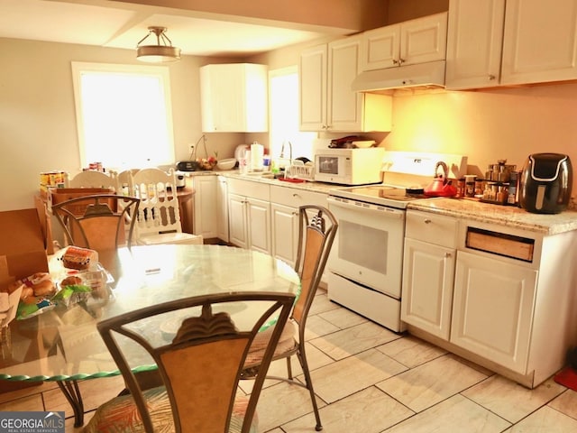 kitchen with white cabinets, light stone countertops, and white appliances