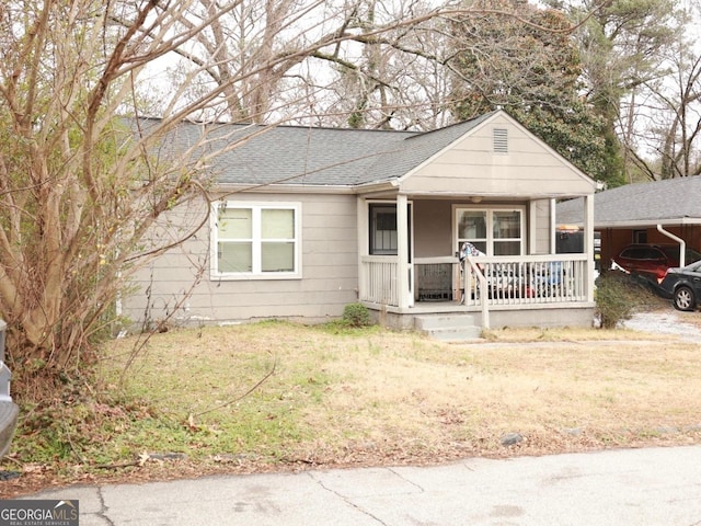 ranch-style home featuring a porch and a front lawn