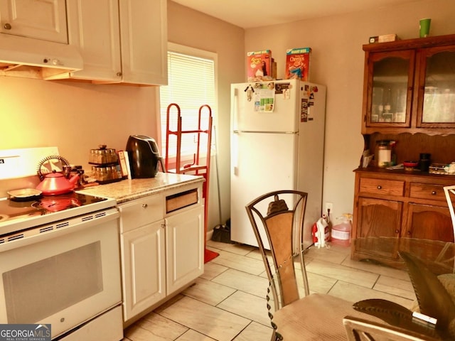 kitchen with white cabinets, light tile patterned floors, white appliances, and ventilation hood