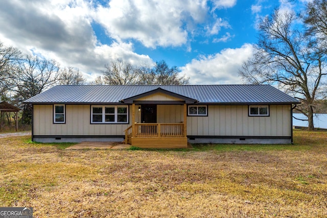 view of front facade with crawl space, metal roof, and a front yard