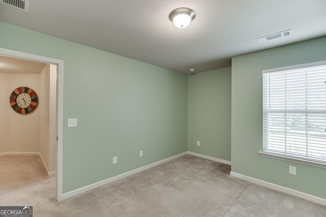 carpeted spare room featuring a wealth of natural light