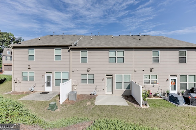 rear view of house featuring cooling unit, a patio area, and a lawn