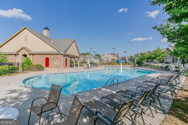 view of swimming pool featuring pool water feature and a patio