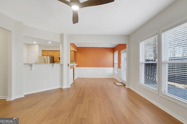 unfurnished living room with ceiling fan and light wood-type flooring