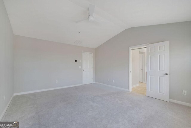 carpeted spare room with ceiling fan and lofted ceiling