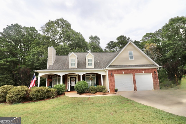 view of front of home featuring a porch, a garage, and a front yard