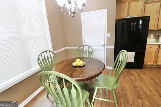 dining space with a notable chandelier and light hardwood / wood-style floors