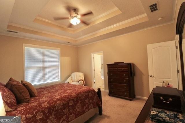 carpeted bedroom featuring a tray ceiling, ceiling fan, and ornamental molding