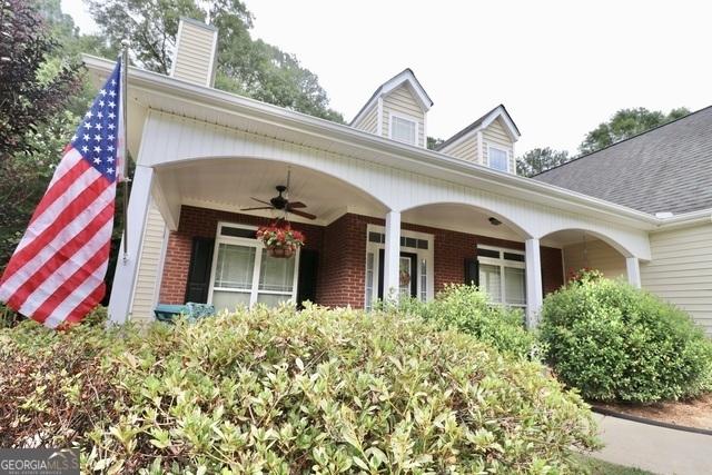 doorway to property with ceiling fan and a porch