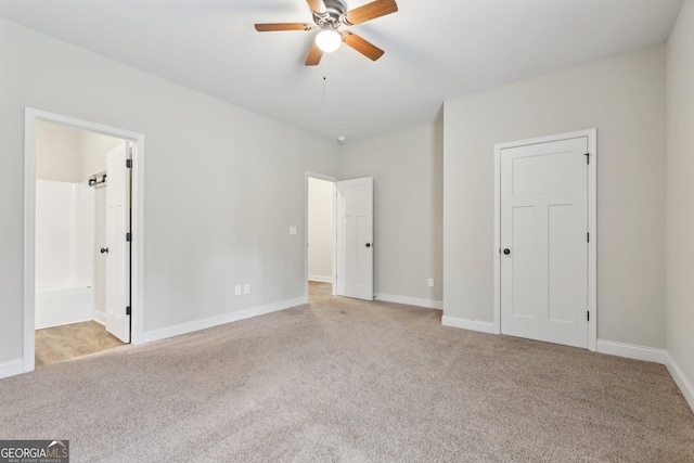 unfurnished bedroom with ceiling fan, light colored carpet, and connected bathroom