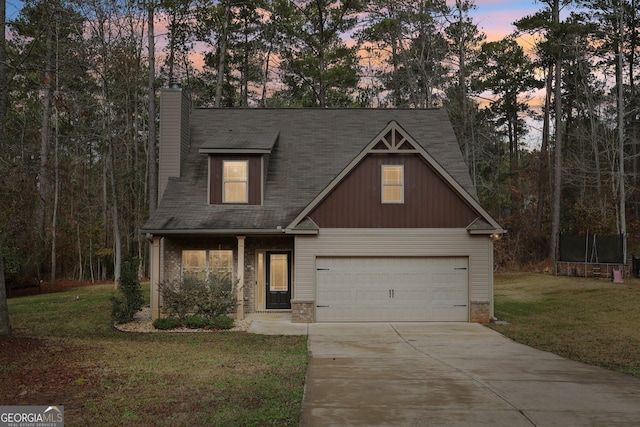 view of front of property featuring a lawn, a garage, and a trampoline