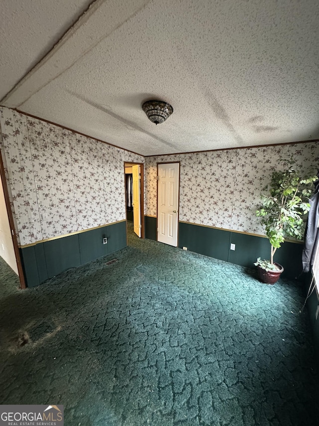 interior space featuring dark carpet and a textured ceiling