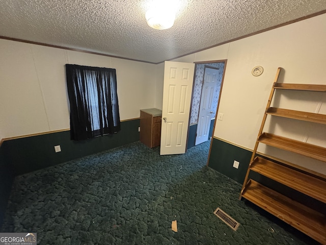 carpeted empty room with a textured ceiling