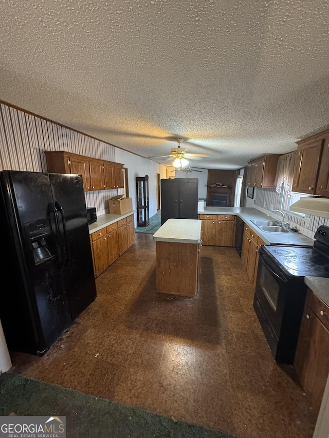 kitchen with ceiling fan, sink, black appliances, a kitchen island, and exhaust hood