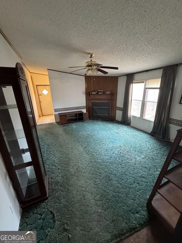 unfurnished living room with dark colored carpet, a textured ceiling, and ceiling fan