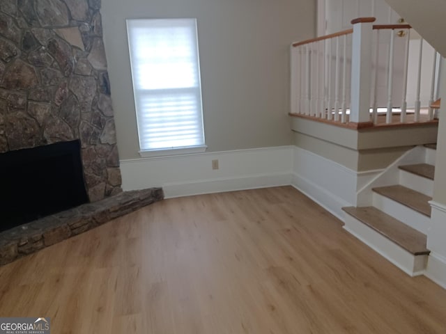 unfurnished living room with a fireplace and light hardwood / wood-style flooring