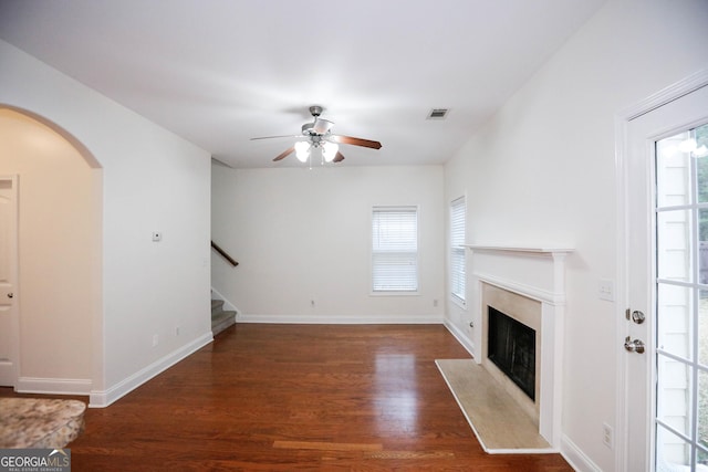 unfurnished living room featuring ceiling fan and dark hardwood / wood-style floors