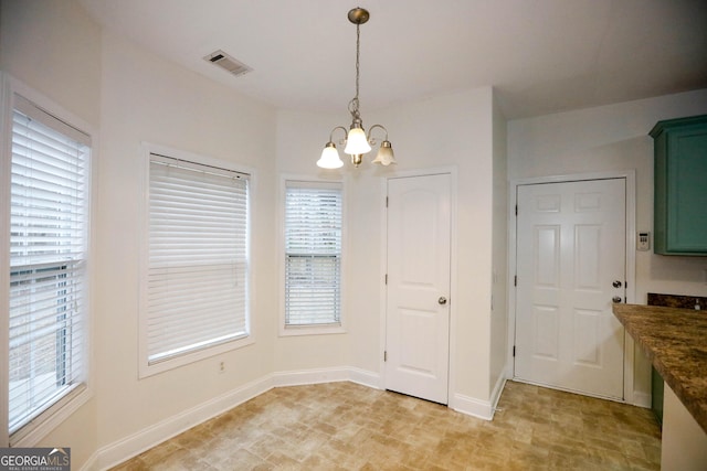 unfurnished dining area with a wealth of natural light and a chandelier