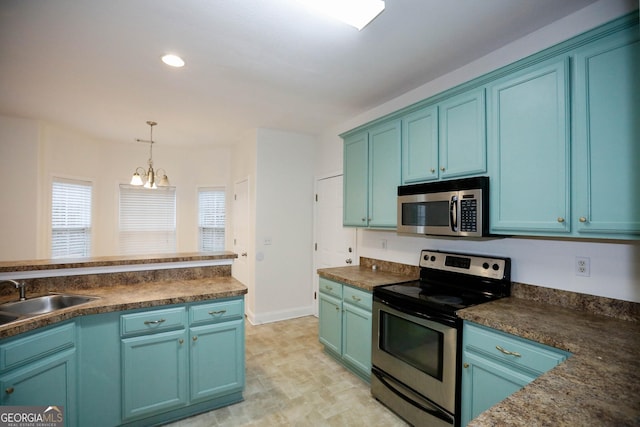 kitchen with blue cabinetry, decorative light fixtures, sink, and stainless steel appliances