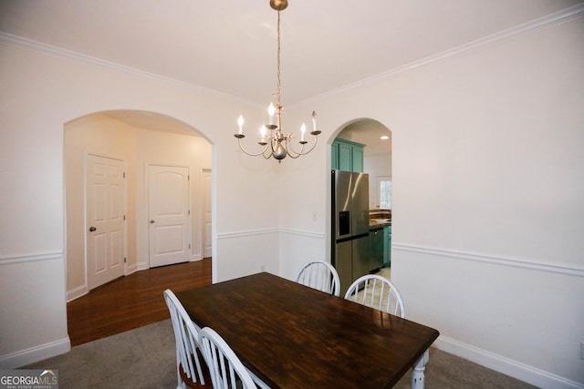 dining room with a chandelier, dark hardwood / wood-style flooring, and crown molding