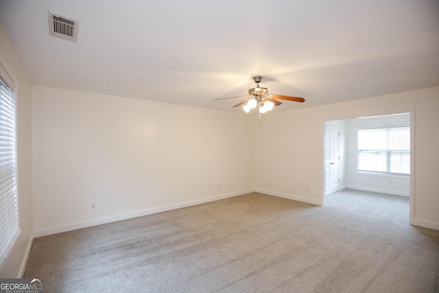 carpeted spare room with ceiling fan