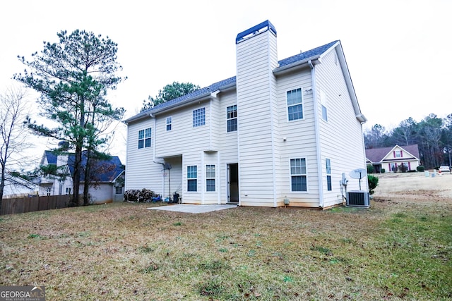 rear view of house featuring a patio area, a yard, and central air condition unit