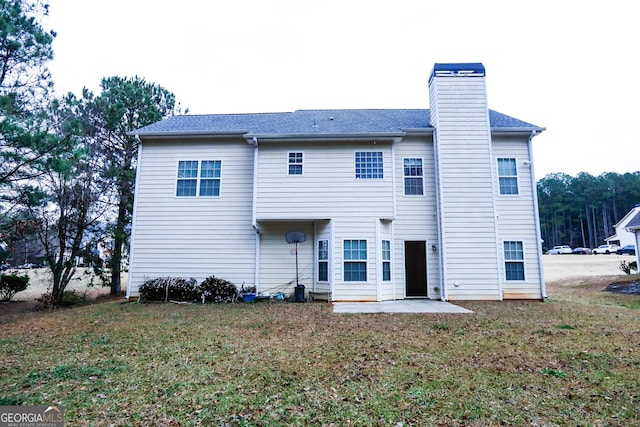 rear view of property featuring a lawn and a patio area