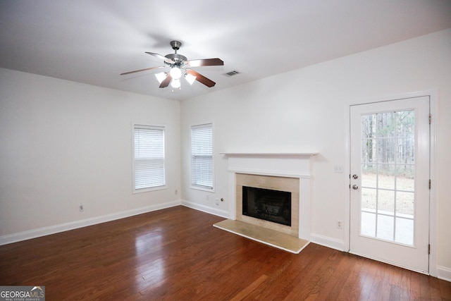 unfurnished living room with a fireplace, dark hardwood / wood-style flooring, and ceiling fan