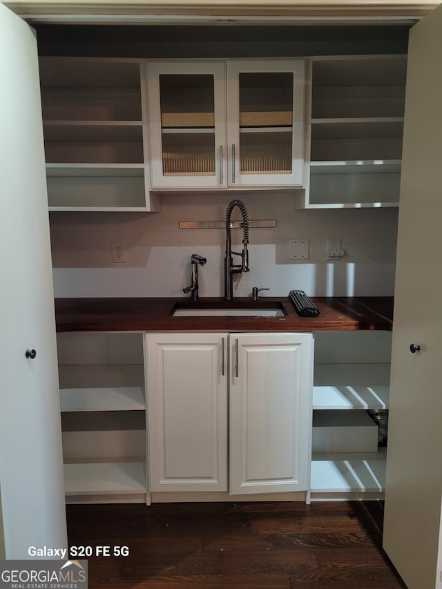 kitchen with white cabinets, dark hardwood / wood-style floors, and sink