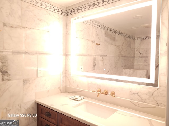 bathroom with vanity and tile walls