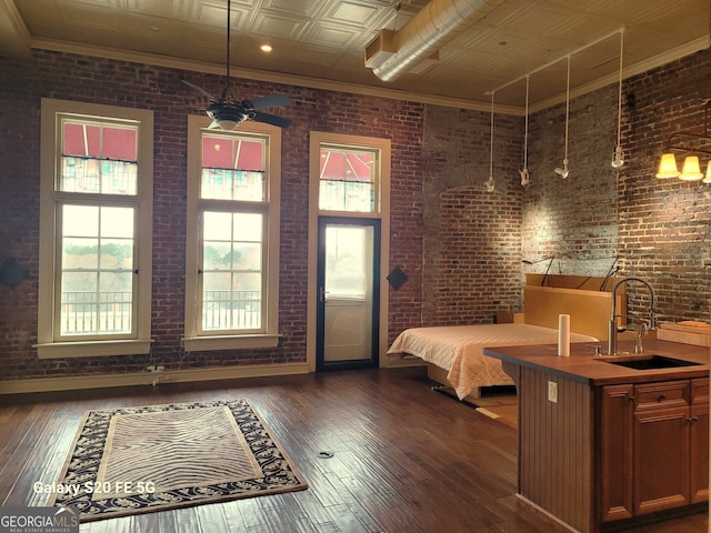 bedroom featuring brick wall, dark wood-type flooring, and sink