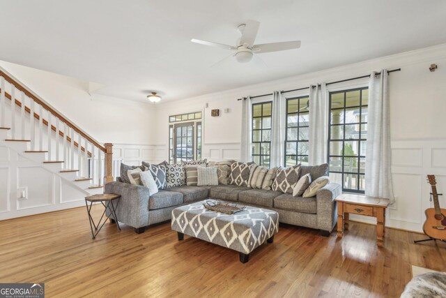 living room featuring wood-type flooring, a wealth of natural light, french doors, and crown molding