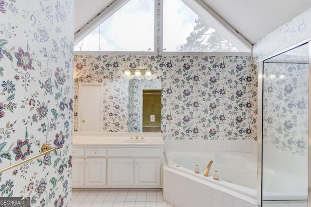 bathroom featuring vanity, a relaxing tiled tub, tile patterned floors, and vaulted ceiling