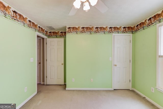 carpeted empty room with ceiling fan and a textured ceiling